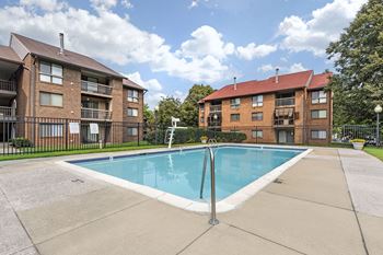 A swimming pool in front of apartment buildings.